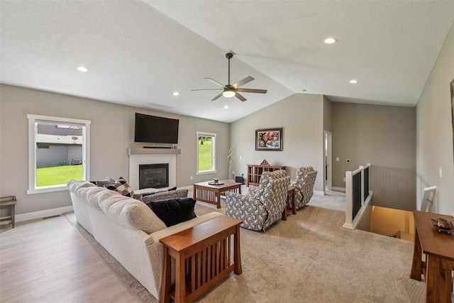 10214 Thorne Dr, West Des Moines, IA 50266 - living room featuring a glass covered fireplace, vaulted ceiling, ceiling fan, recessed lighting, and light wood finished floors