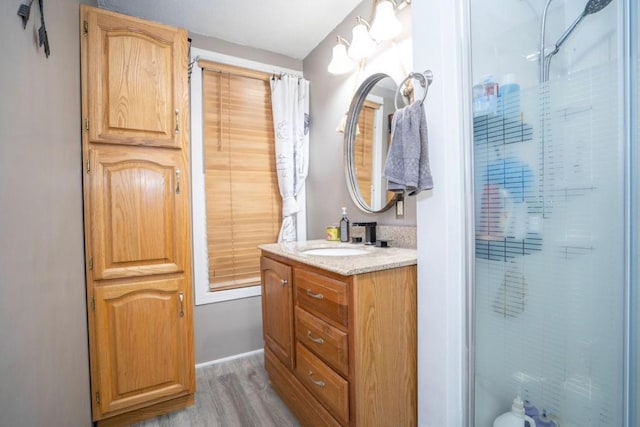 314 E 3rd St N, Newton, IA 50208 - bathroom with wood finished floors, vanity, and a shower
