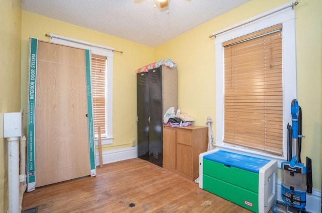 314 E 3rd St N, Newton, IA 50208 - bedroom featuring wood finished floors, a textured ceiling, and a ceiling fan