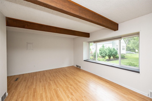 1144 57th St, Des Moines, IA 50311 - empty room with beamed ceiling and light wood finished floors