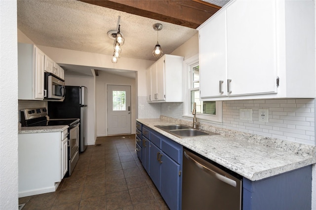 1144 57th St, Des Moines, IA 50311 - kitchen with stainless steel appliances, blue cabinets, backsplash, white cabinets, and dark tile patterned floors