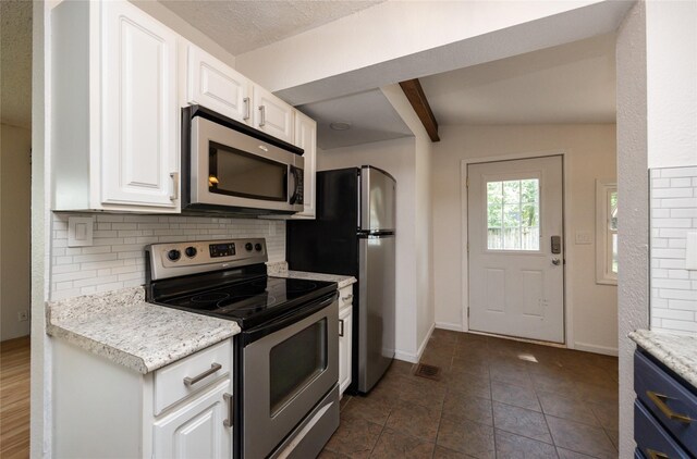 1144 57th St, Des Moines, IA 50311 - kitchen with appliances with stainless steel finishes, decorative backsplash, beamed ceiling, light countertops, and white cabinetry