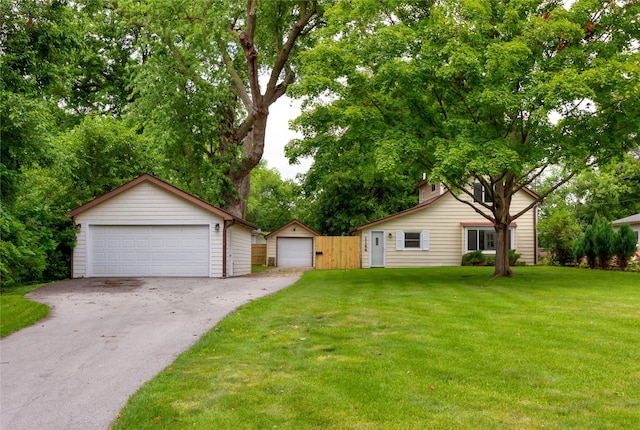 1144 57th St, Des Moines, IA 50311 - view of front of house with a detached garage, an outbuilding, and a front yard