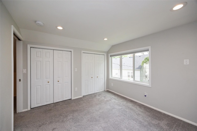 1144 57th St, Des Moines, IA 50311 - unfurnished bedroom featuring two closets, recessed lighting, carpet floors, and lofted ceiling