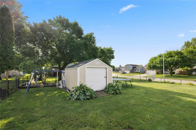 1215 7th Ave SE, Altoona, IA 50009 - fenced backyard featuring a trampoline, a storage unit, a playground, and a residential view