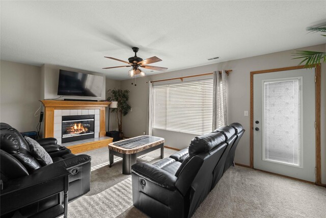 1215 7th Ave SE, Altoona, IA 50009 - carpeted living area featuring a tiled fireplace and a ceiling fan