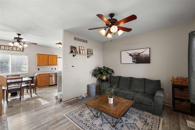 1215 7th Ave SE, Altoona, IA 50009 - living area featuring a ceiling fan and light wood-style flooring