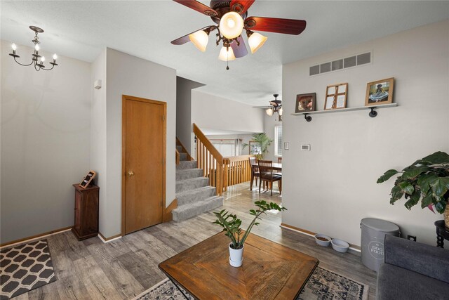1215 7th Ave SE, Altoona, IA 50009 - living area with ceiling fan, wood finished floors, stairs, and a chandelier
