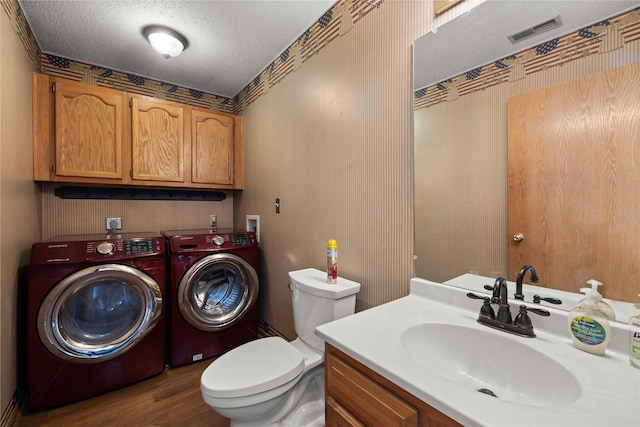 1215 7th Ave SE, Altoona, IA 50009 - bathroom featuring washer and clothes dryer, a textured ceiling, vanity, and wood finished floors