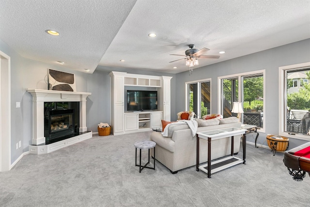 15222 Wilden Dr, Urbandale, IA 50323 - living room with light carpet, ceiling fan, a textured ceiling, recessed lighting, and a fireplace