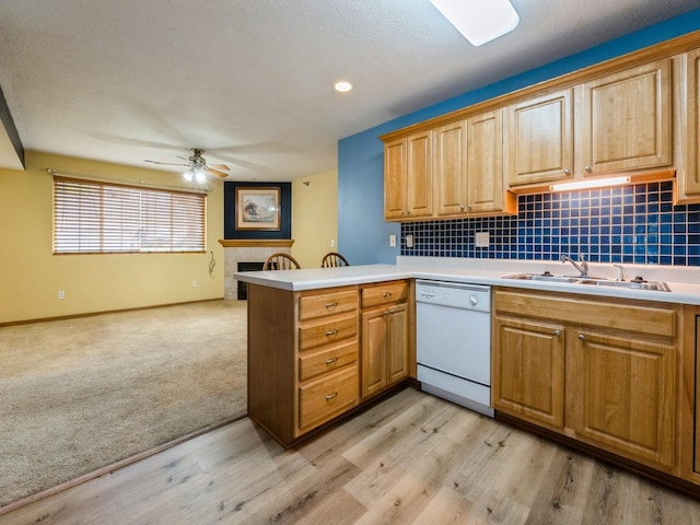 5908 Sutton Pl Unit 1, Urbandale, IA 50322 - kitchen featuring white dishwasher, a peninsula, ceiling fan, and backsplash