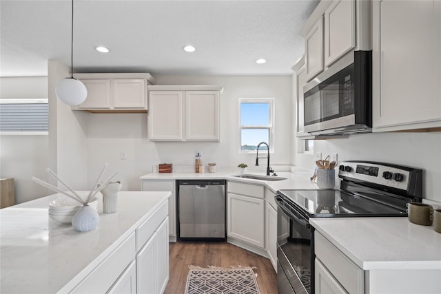 305 S Valley View Dr, Norwalk, IA 50211 - kitchen featuring appliances with stainless steel finishes, recessed lighting, hanging light fixtures, dark wood-type flooring, and white cabinetry