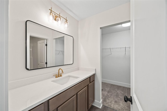 305 S Valley View Dr, Norwalk, IA 50211 - bathroom featuring vanity, a walk in closet, and wood finished floors