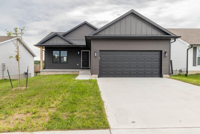 305 S Valley View Dr, Norwalk, IA 50211 - view of front of house with board and batten siding, an attached garage, concrete driveway, and a front lawn