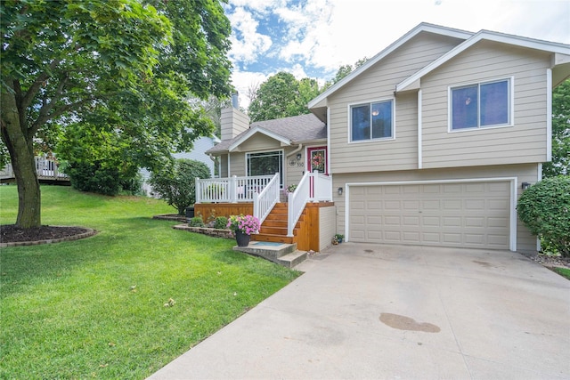 530 N 9th St, Carlisle, IA 50047 - split level home featuring a garage, a chimney, a front yard, concrete driveway, and a deck