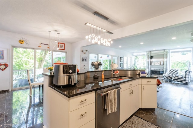 4709 Colt Dr, West Des Moines, IA 50265 - kitchen with stainless steel dishwasher, healthy amount of natural light, hanging light fixtures, dark stone countertops, and recessed lighting