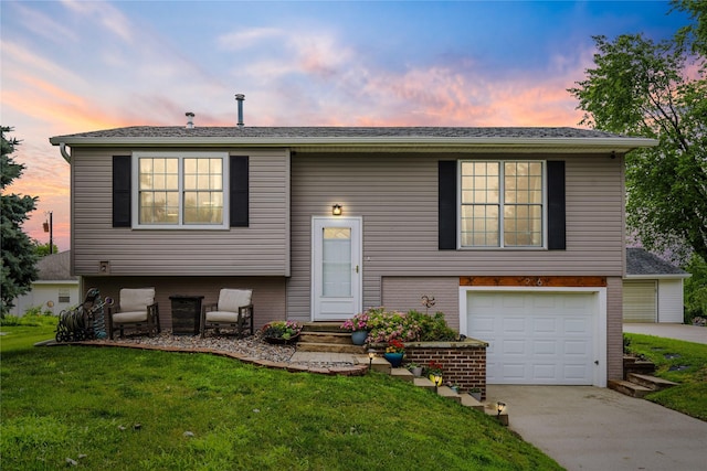 206 Main St, Grinnell, IA 50112 - bi-level home with a front yard, an attached garage, and concrete driveway