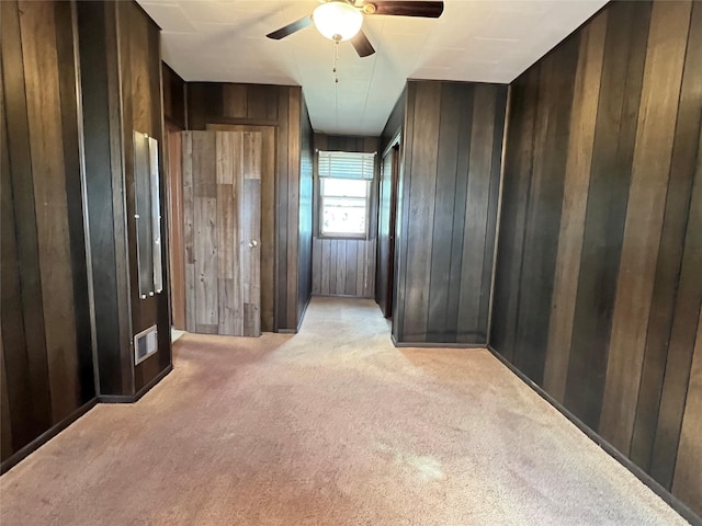 6285 E 28th St N, Newton, IA 50208 - spare room with light colored carpet, wooden walls, and ceiling fan