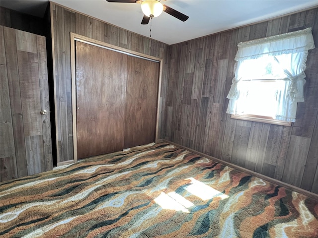 6285 E 28th St N, Newton, IA 50208 - bedroom with wood walls, a ceiling fan, and a closet