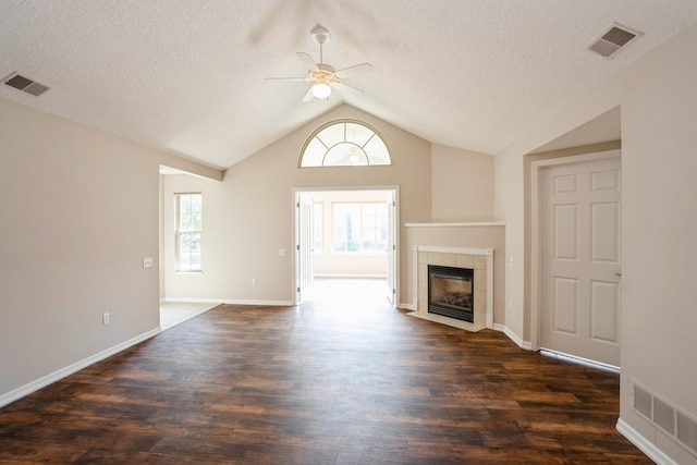 3305 SE Glenstone Dr Unit 172, Grimes, IA 50111 - unfurnished living room with a ceiling fan, lofted ceiling, dark wood finished floors, a fireplace, and a textured ceiling