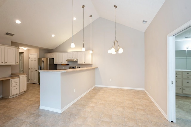 3305 SE Glenstone Dr Unit 172, Grimes, IA 50111 - kitchen with a peninsula, white cabinets, under cabinet range hood, high vaulted ceiling, and a chandelier