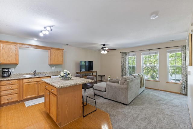 8302 Westown Pkwy Unit 8110, West Des Moines, IA 50266 - kitchen featuring a kitchen island, a kitchen breakfast bar, a ceiling fan, and open floor plan