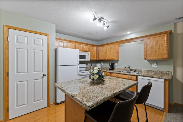 8302 Westown Pkwy Unit 8110, West Des Moines, IA 50266 - kitchen with white appliances, a breakfast bar, a center island, light wood-style floors, and recessed lighting