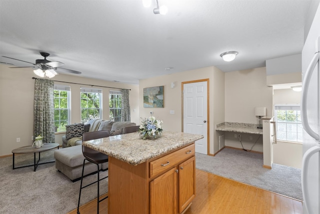 8302 Westown Pkwy Unit 8110, West Des Moines, IA 50266 - kitchen with healthy amount of natural light, a breakfast bar area, open floor plan, and a kitchen island