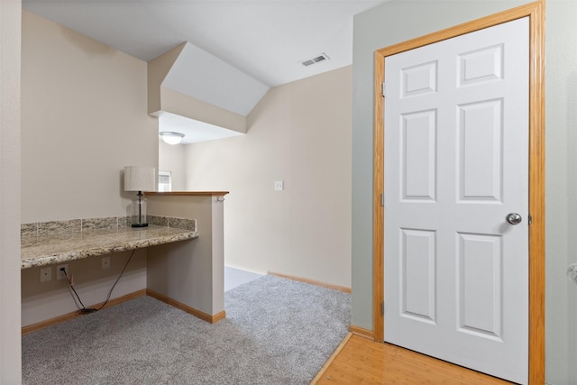 8302 Westown Pkwy Unit 8110, West Des Moines, IA 50266 - kitchen with built in study area, light wood-style flooring, and light stone counters