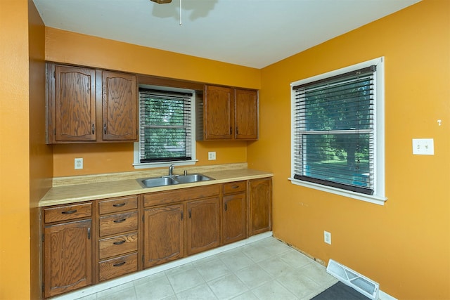 832 E Lacona Ave, Des Moines, IA 50315 - kitchen featuring light countertops, brown cabinetry, and a ceiling fan