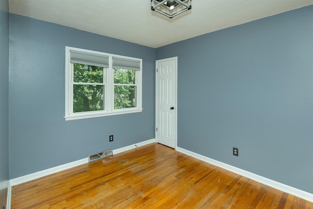 832 E Lacona Ave, Des Moines, IA 50315 - unfurnished room featuring baseboards and hardwood / wood-style flooring