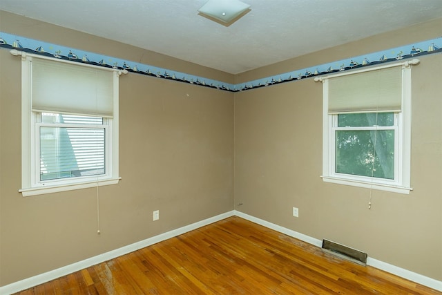 832 E Lacona Ave, Des Moines, IA 50315 - spare room with baseboards and wood finished floors