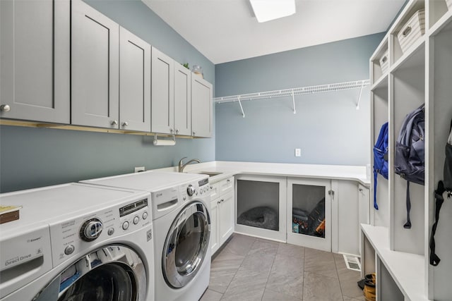 14638 Woodcrest Dr, Clive, IA 50325 - laundry area featuring washing machine and dryer, cabinet space, and light marble finish flooring