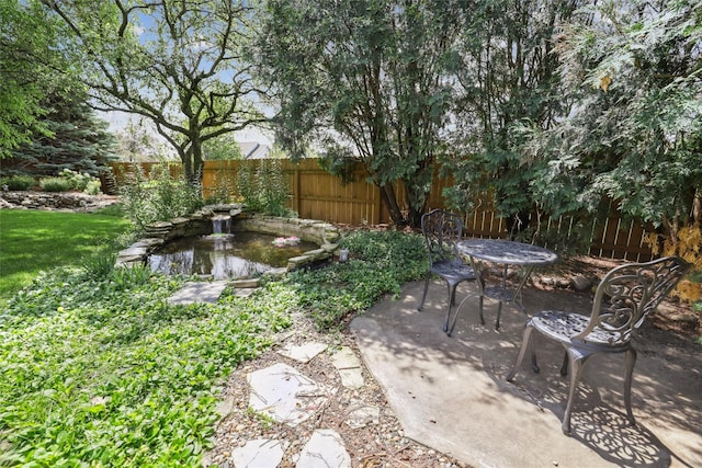 14638 Woodcrest Dr, Clive, IA 50325 - fenced backyard with a small pond and a patio