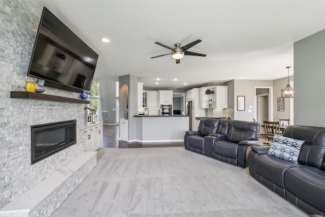 14638 Woodcrest Dr, Clive, IA 50325 - carpeted living room with a ceiling fan, a stone fireplace, recessed lighting, and a chandelier