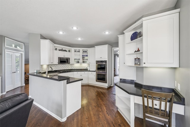 14638 Woodcrest Dr, Clive, IA 50325 - kitchen featuring open shelves, stainless steel appliances, a peninsula, dark countertops, and dark wood-style flooring