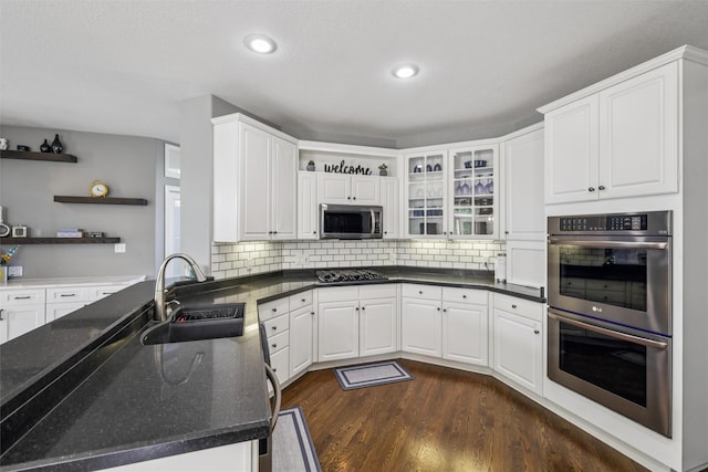 14638 Woodcrest Dr, Clive, IA 50325 - kitchen featuring stainless steel appliances, open shelves, dark wood-style floors, white cabinets, and tasteful backsplash