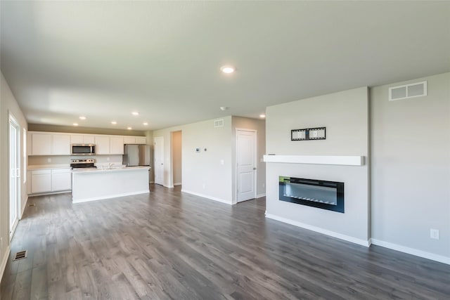 4404 NE 16th St, Ankeny, IA 50021 - unfurnished living room with dark wood-style floors, recessed lighting, and a glass covered fireplace