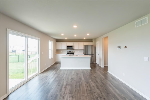 4404 NE 16th St, Ankeny, IA 50021 - kitchen featuring appliances with stainless steel finishes, dark wood-style floors, white cabinetry, an island with sink, and light countertops