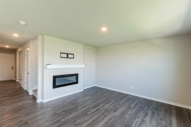4404 NE 16th St, Ankeny, IA 50021 - unfurnished living room with dark wood-style floors, a glass covered fireplace, and recessed lighting