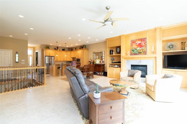 862 Glen Oaks Ter, West Des Moines, IA 50266 - living room featuring a glass covered fireplace, recessed lighting, ceiling fan, built in shelves, and light tile patterned flooring