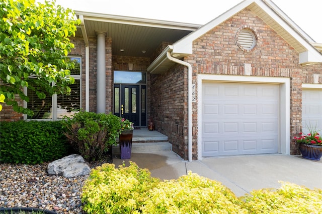 862 Glen Oaks Ter, West Des Moines, IA 50266 - view of exterior entry with brick siding, an attached garage, and concrete driveway