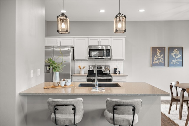 832 Kinney Cir NE, Bondurant, IA 50035 - kitchen featuring stainless steel appliances, white cabinetry, backsplash, a breakfast bar, and recessed lighting