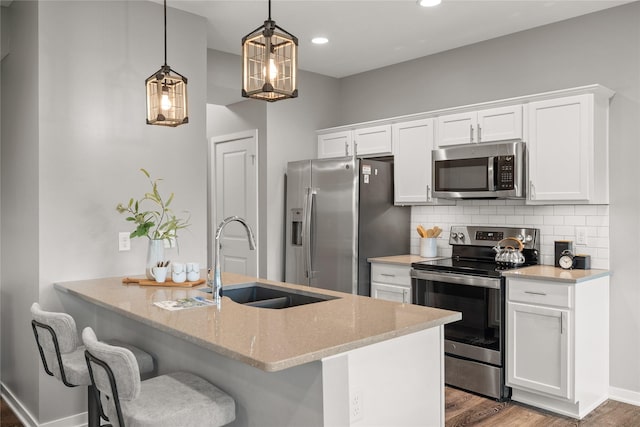 832 Kinney Cir NE, Bondurant, IA 50035 - kitchen featuring stainless steel appliances, light stone counters, wood finished floors, decorative backsplash, and white cabinets