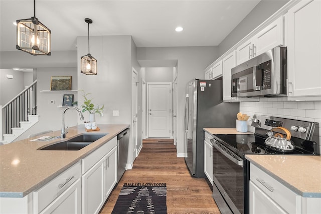 832 Kinney Cir NE, Bondurant, IA 50035 - kitchen featuring stainless steel appliances, wood finished floors, white cabinetry, tasteful backsplash, and recessed lighting