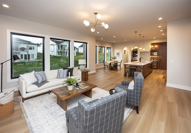 1128 NW 29th Ct, Grimes, IA 50111 - living area featuring a chandelier, light wood-style floors, recessed lighting, and arched walkways
