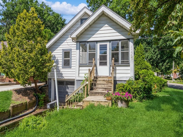 2928 34th St, Des Moines, IA 50310 - view of front of property featuring a front lawn, a sunroom, and entry steps