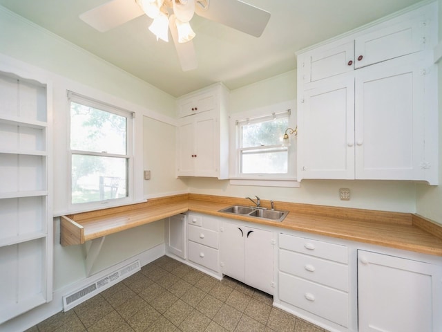 2928 34th St, Des Moines, IA 50310 - kitchen featuring white cabinets, light countertops, and a ceiling fan