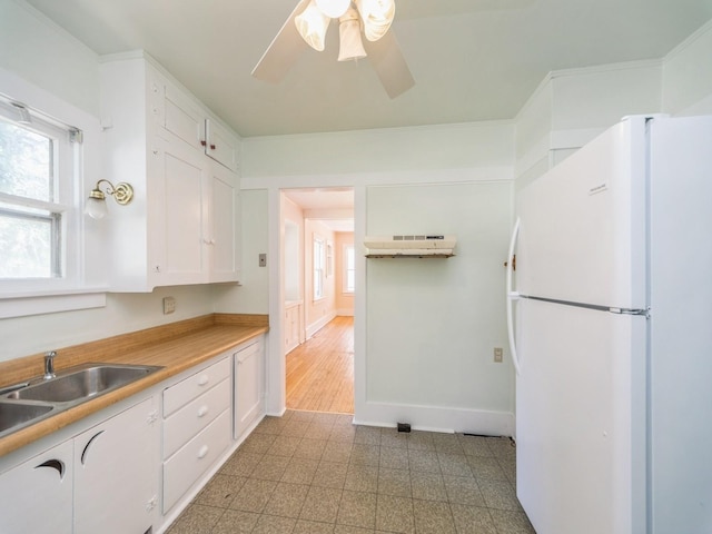 2928 34th St, Des Moines, IA 50310 - kitchen featuring freestanding refrigerator, white cabinetry, healthy amount of natural light, and ceiling fan