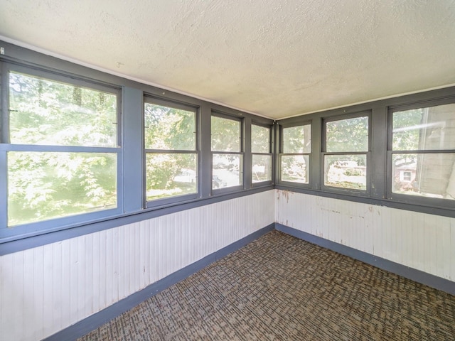 2928 34th St, Des Moines, IA 50310 - unfurnished sunroom featuring a textured ceiling, plenty of natural light, carpet, and wood walls